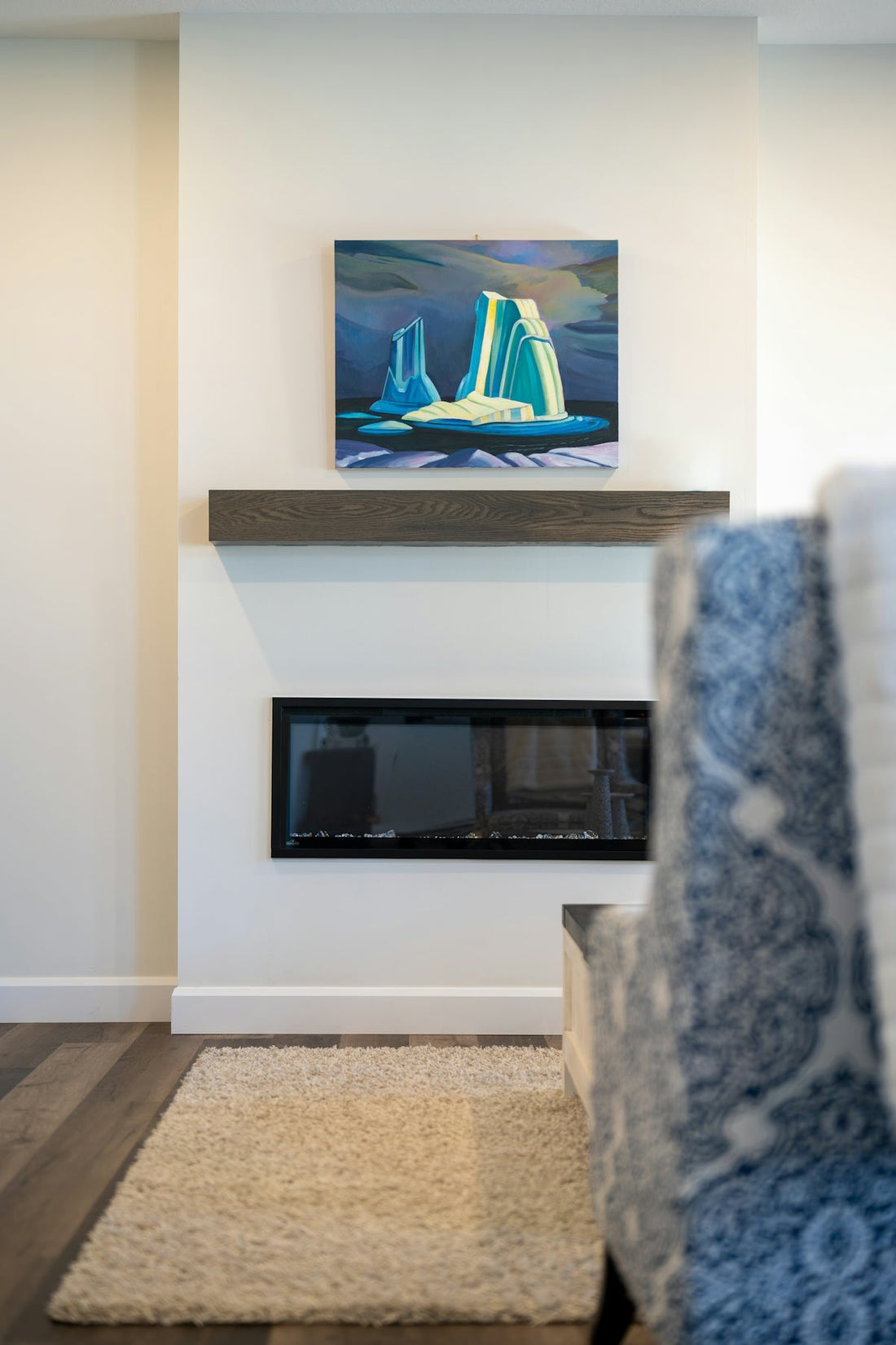 Modern fireplace with abstract art above mantel.