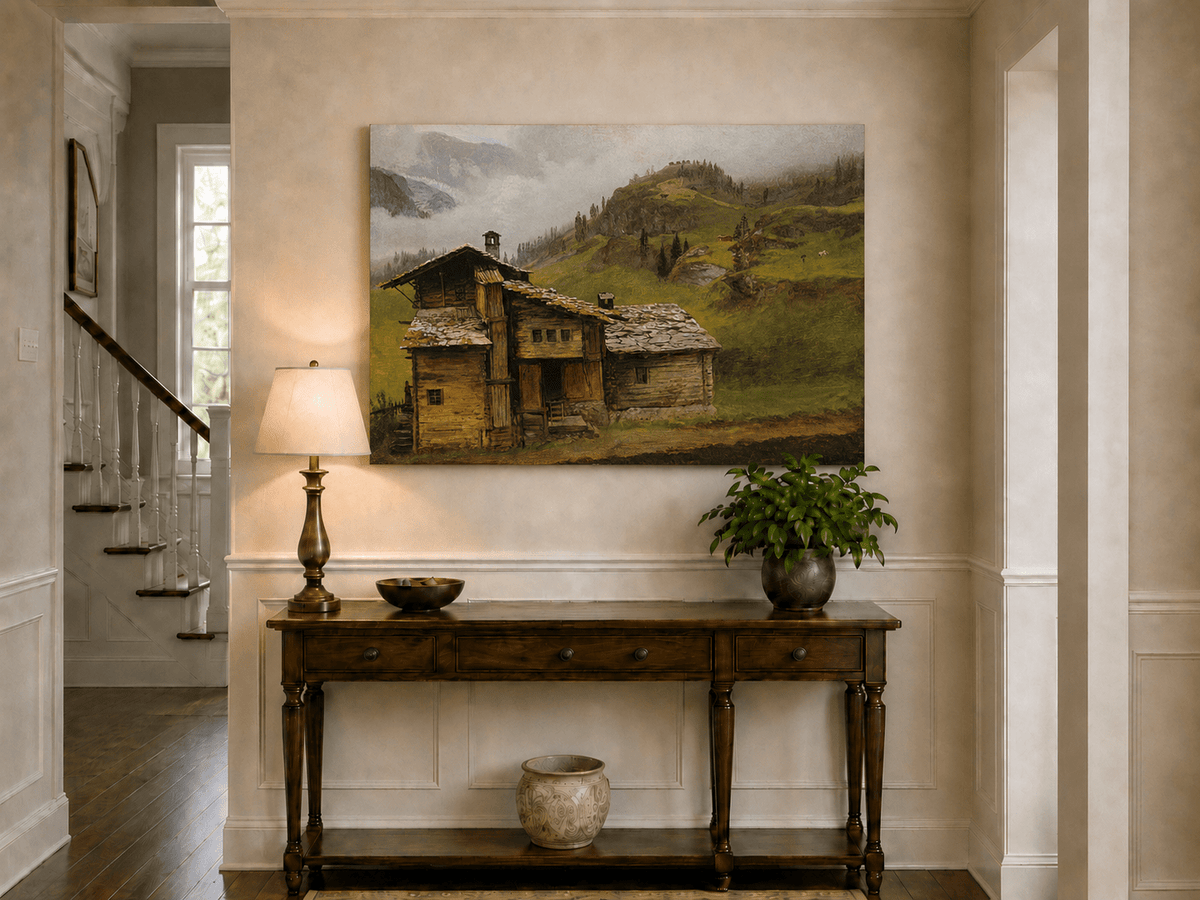 Unframed hand-painted alpine landscape oil painting with a chalet, pasture and bell tower displayed above an entryway console table.