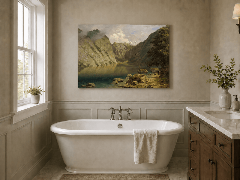 Unframed hand-painted alpine lake valley oil painting with a waterfall and rugged mountains displayed above a freestanding bathtub.