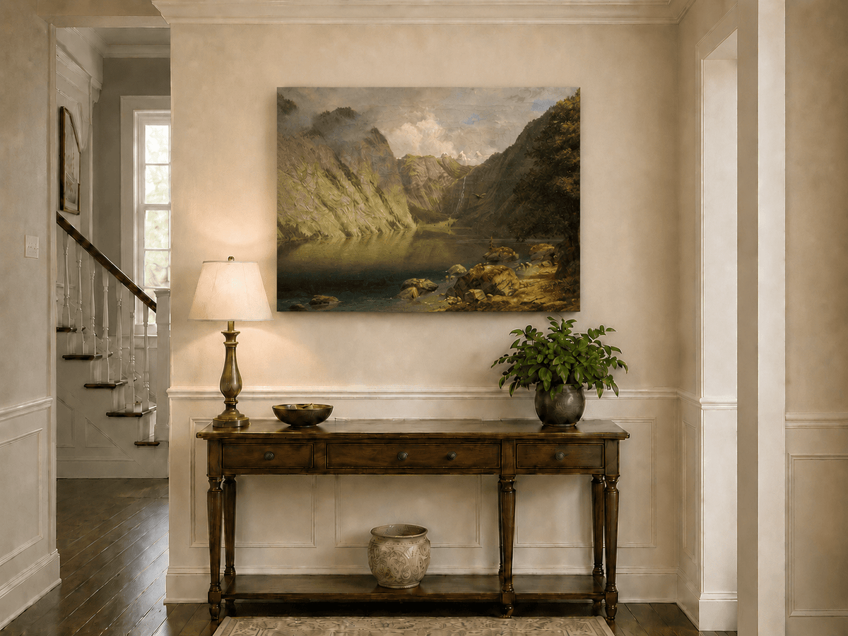 Unframed hand-painted alpine lake valley oil painting with a waterfall and rugged mountains displayed above an entryway console table.