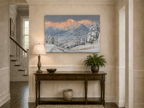 Unframed hand-painted alpine town oil painting beneath glowing pink mountain peaks displayed above an entryway console table.