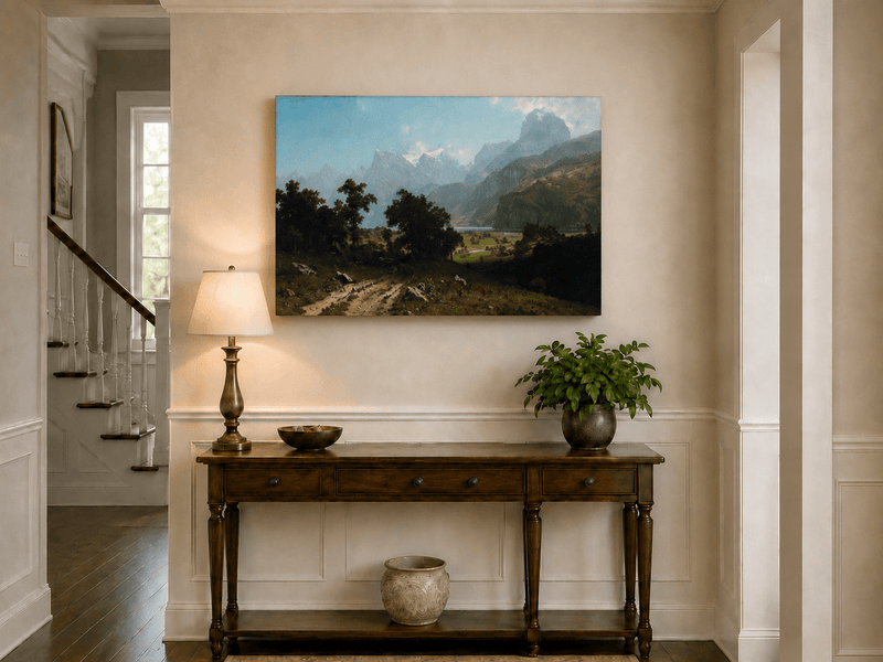 Unframed hand-painted alpine valley oil painting with a lake and layered mountain peaks displayed above an entryway console table.