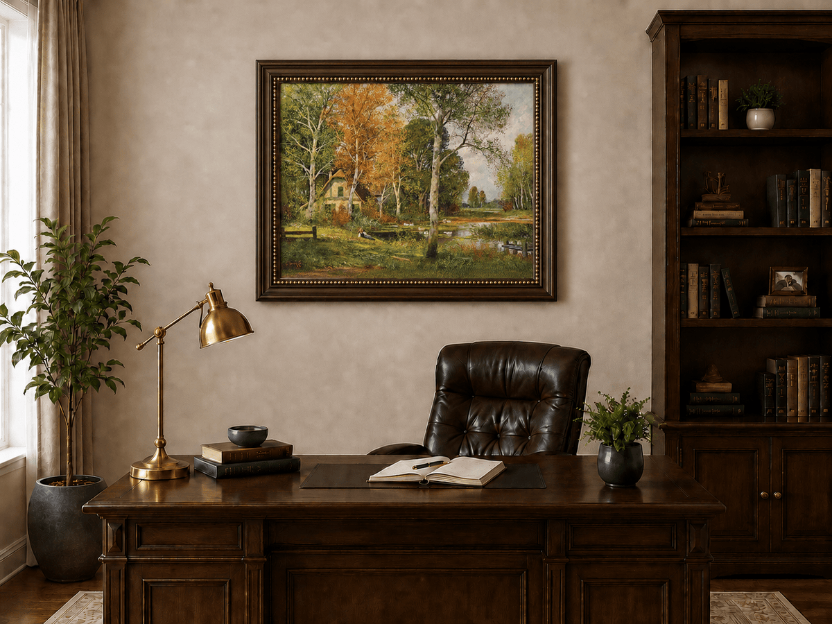 Framed hand-painted autumn riverside oil painting with a cottage among golden birch trees displayed above a traditional home office desk.