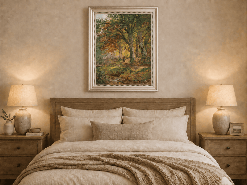 Framed hand-painted autumn forest oil painting with a leaf-covered path beside a stream displayed above a wooden bed in a neutral bedroom.