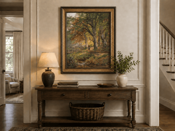 Framed hand-painted autumn forest oil painting with a leaf-covered path beside a stream displayed above an entryway console table.