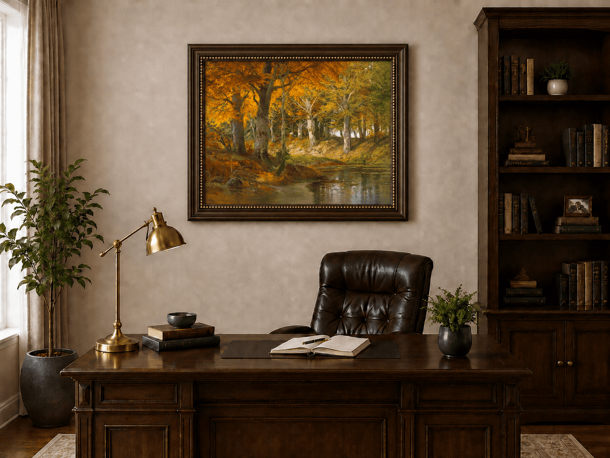 Framed hand-painted autumn forest stream oil painting glowing beneath golden trees displayed above a traditional home office desk.