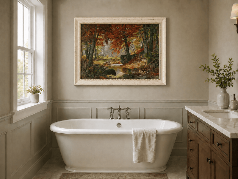 Framed hand-painted autumn forest stream oil painting flowing around mossy boulders displayed above a freestanding bathtub.