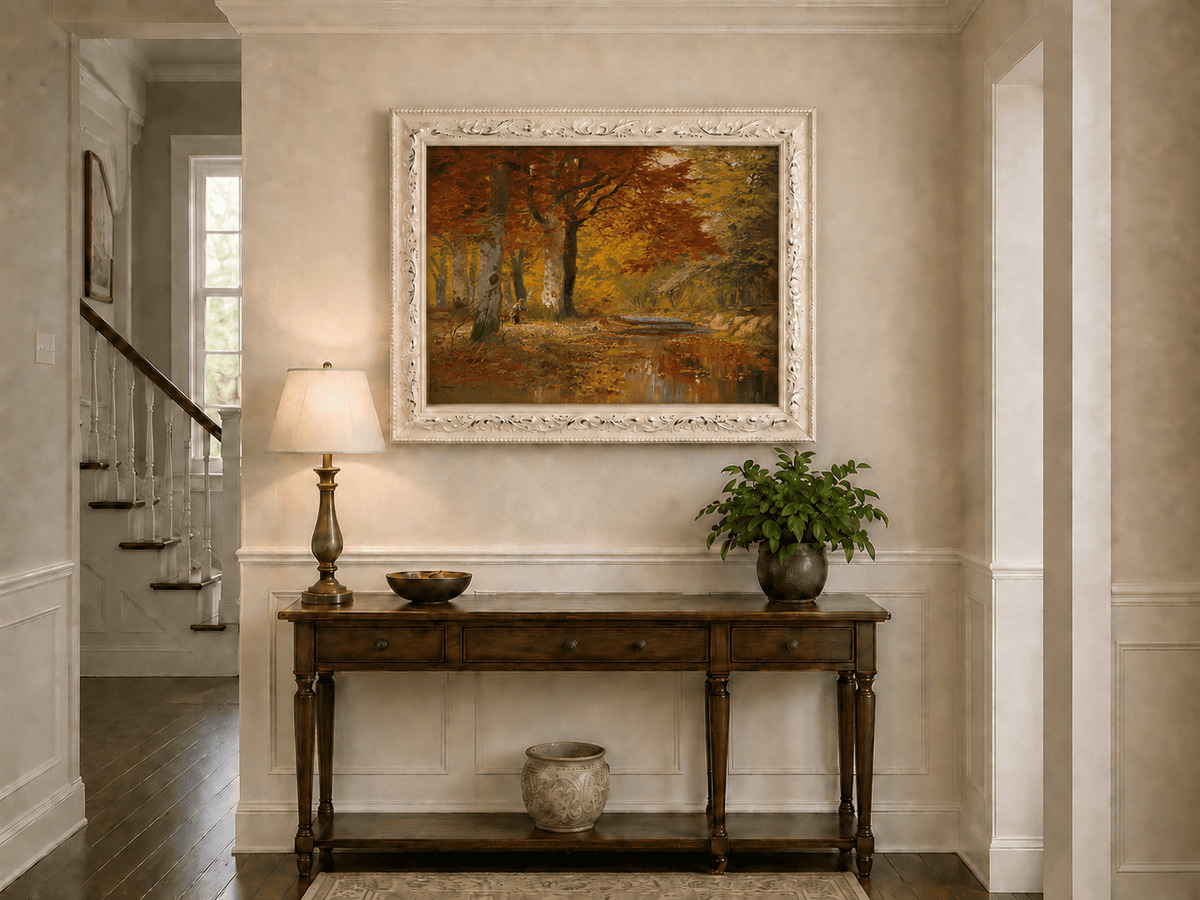 Framed hand-painted autumn forest oil painting with a stream and red-leaved trees displayed above an entryway console table.