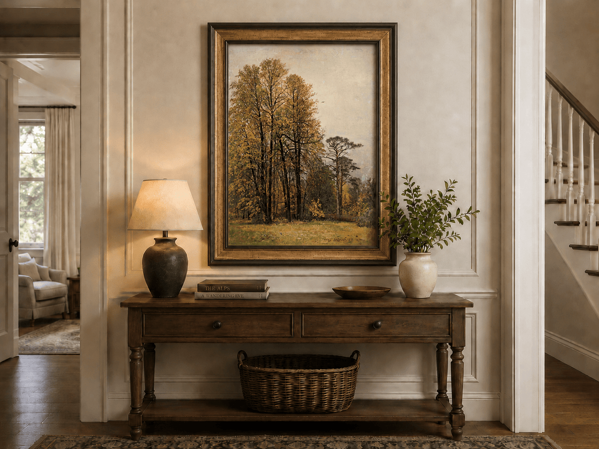 Framed hand-painted autumn forest oil painting with tall golden-leaved trees displayed above an entryway console table.