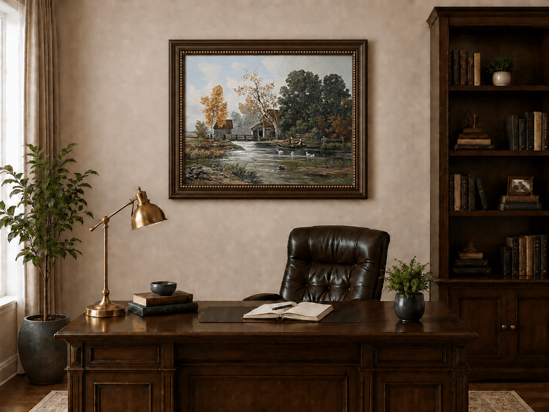 Framed hand-painted autumn river mill oil painting with a boat and swans on the water displayed above a traditional home office desk.