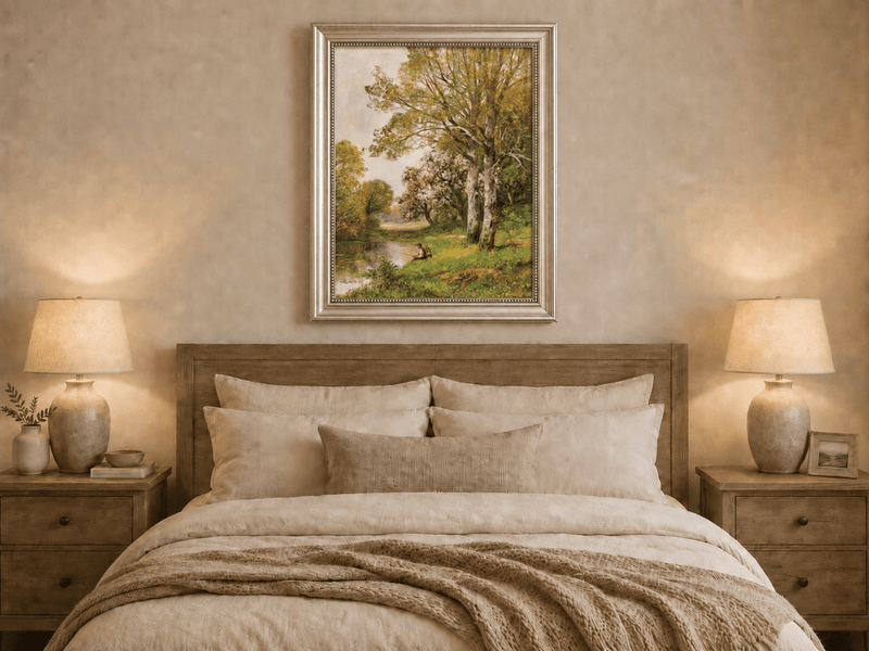 Framed hand-painted autumn riverside oil painting with a seated figure beneath birch trees displayed above a wooden bed in a neutral bedroom.