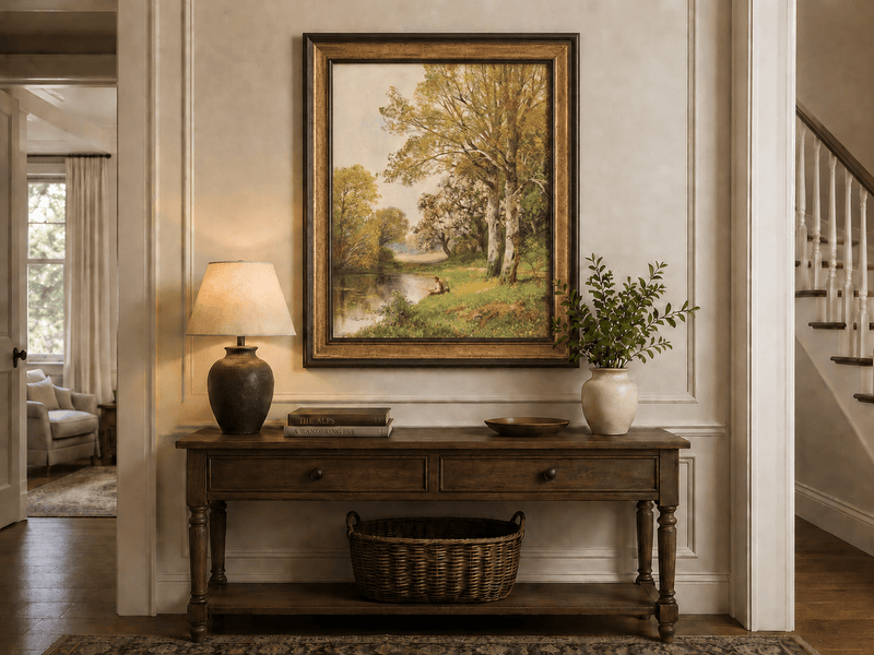 Framed hand-painted autumn riverside oil painting with a seated figure beneath birch trees displayed above an entryway console table.