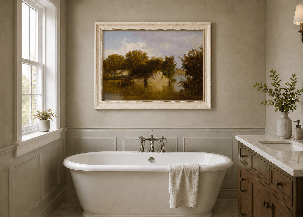 Framed hand-painted autumn river oil painting with golden trees, a rocky bank and reflections displayed above a freestanding bathtub.