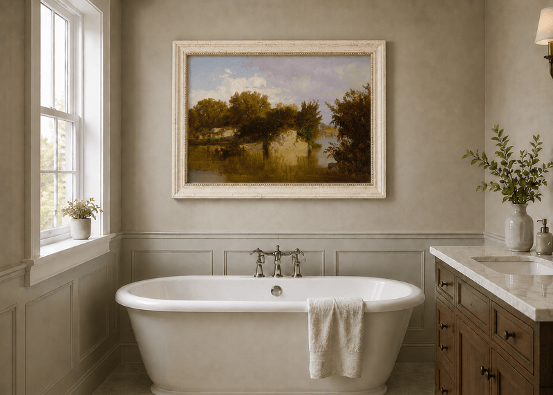 Framed hand-painted autumn river oil painting with golden trees, a rocky bank and reflections displayed above a freestanding bathtub.