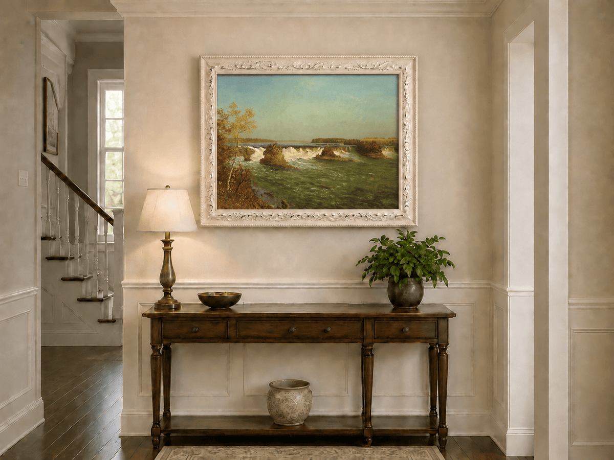 Framed hand-painted autumn waterfall oil painting with rocky islands and a broad river displayed above an entryway console table.