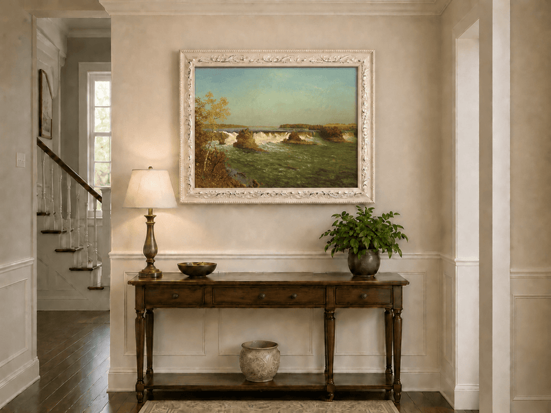 Framed hand-painted autumn waterfall oil painting with rocky islands and a broad river displayed above an entryway console table.