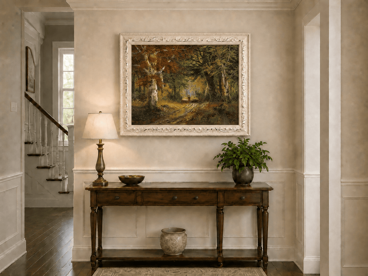 Framed hand-painted autumn woodland path oil painting beneath tall golden trees displayed above an entryway console table.