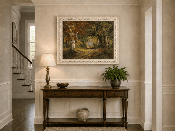 Framed hand-painted autumn woodland path oil painting beneath tall golden trees displayed above an entryway console table.