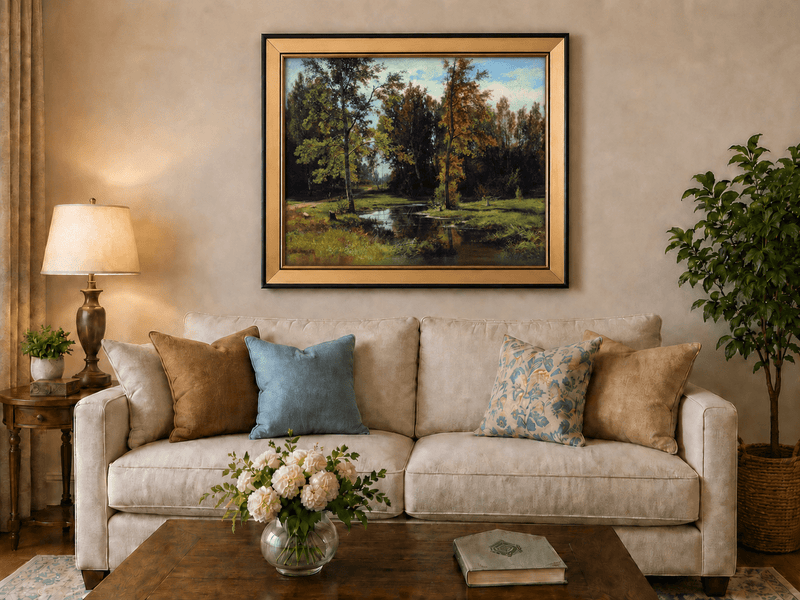 Framed hand-painted autumn woodland pond oil painting with trees reflected in still water displayed above a neutral living room sofa.