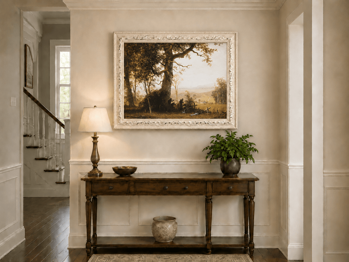 Framed hand-painted historical landscape oil painting with a battle scene in the forest displayed above an entryway console table.