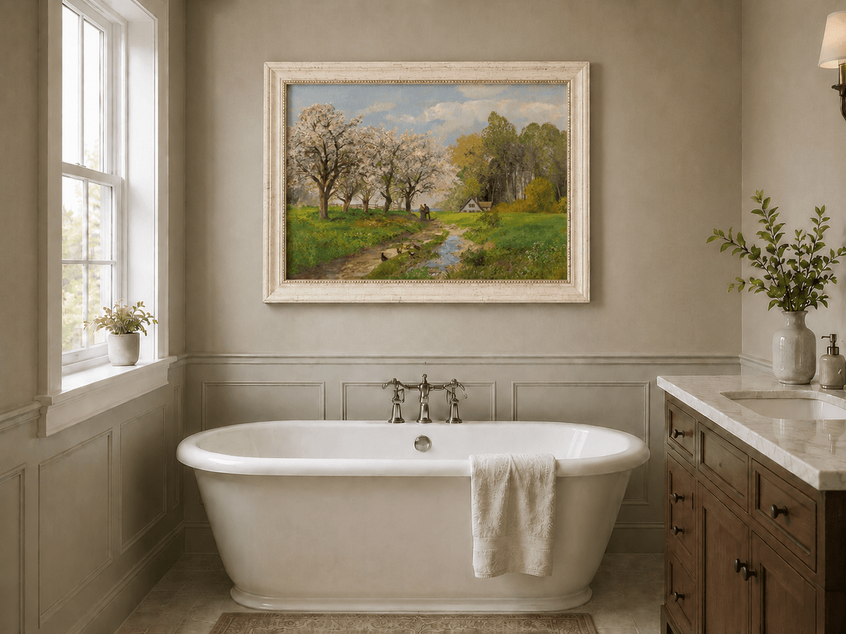 Framed hand-painted blooming orchard oil painting with a winding path leading to a cottage displayed above a freestanding bathtub.