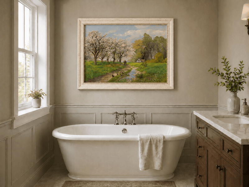 Framed hand-painted blooming orchard oil painting with a winding path leading to a cottage displayed above a freestanding bathtub.