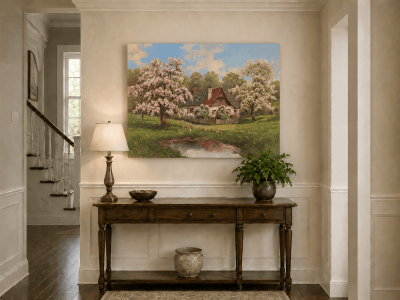 Unframed hand-painted spring cottage oil painting surrounded by blossoming trees beside a quiet pond displayed above an entryway console table.