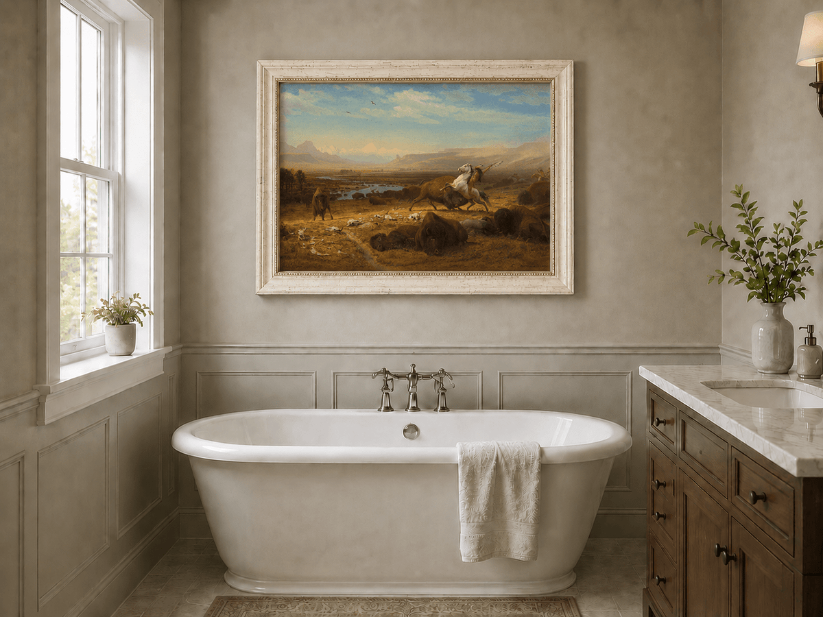 Framed hand-painted western landscape oil painting of a buffalo hunt across open prairie displayed above a freestanding bathtub.