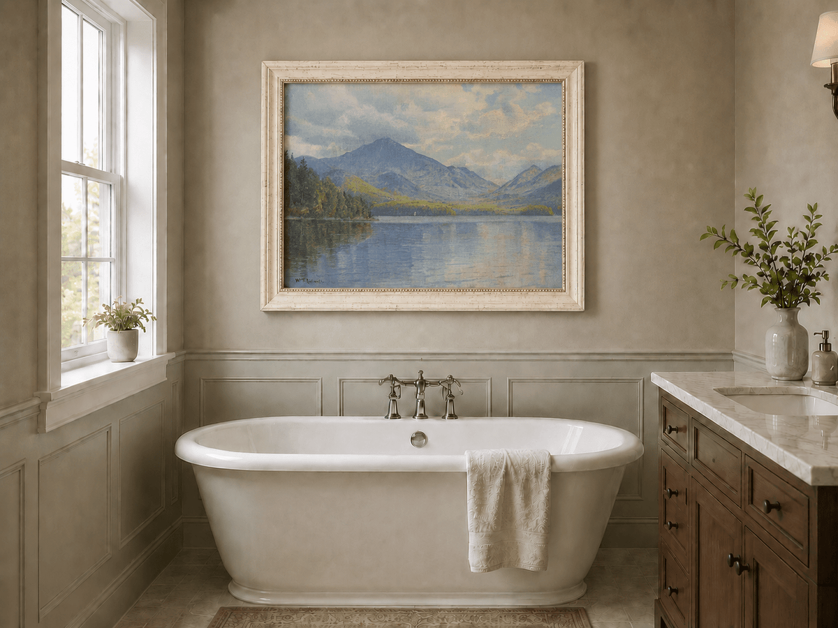 Framed hand-painted lake oil painting with calm reflections and a forested shoreline displayed above a freestanding bathtub.