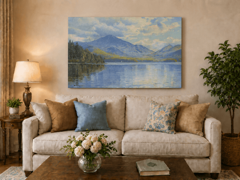 Unframed hand-painted lake oil painting with calm reflections and a forested shoreline displayed above a neutral living room sofa.