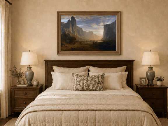 Framed hand-painted cliffs and river oil painting illuminated by warm golden light displayed above a wooden bed in a neutral bedroom.