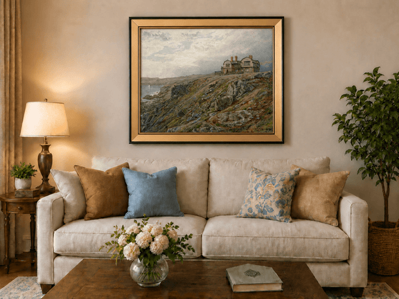 Framed hand-painted coastal oil painting with a cliff house, rocky slopes and seaside view displayed above a neutral living room sofa.
