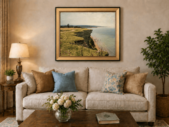 Framed hand-painted coastal landscape oil painting with a grassy cliff and expansive sea view displayed above a neutral living room sofa.