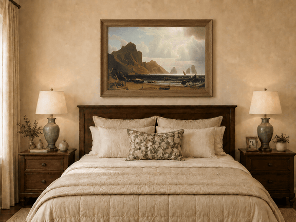 Framed hand-painted coastal cliffs oil painting with fishing boats and figures on a rocky beach displayed above a wooden bed in a neutral bedroom.