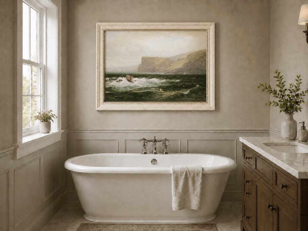 Framed hand-painted seascape oil painting with coastal cliffs, crashing waves and a seaside rock displayed above a freestanding bathtub.