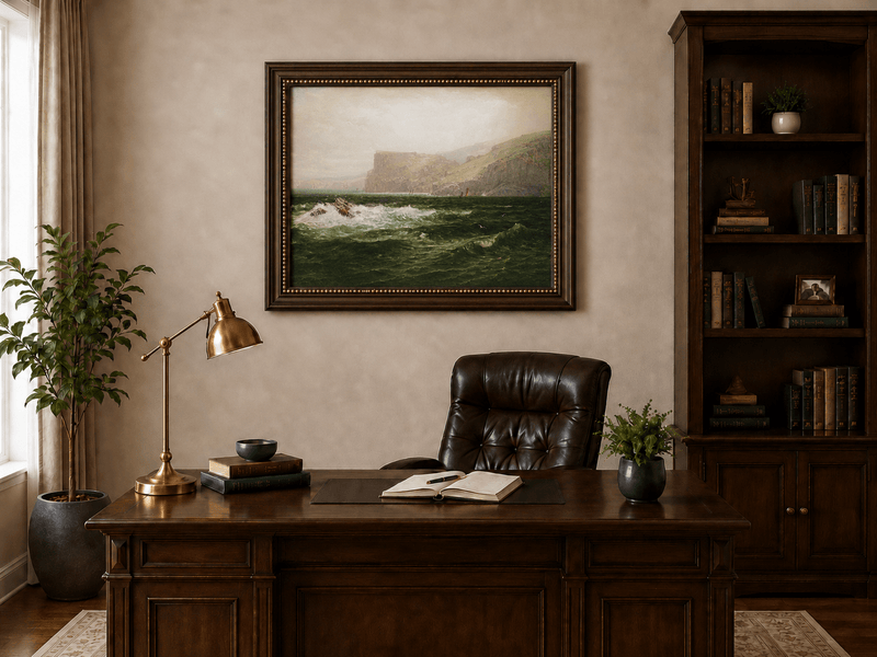 Framed hand-painted seascape oil painting with coastal cliffs, crashing waves and a seaside rock displayed above a traditional home office desk.
