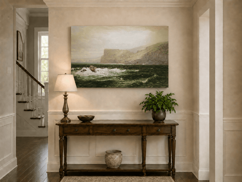 Unframed hand-painted seascape oil painting with coastal cliffs, crashing waves and a seaside rock displayed above an entryway console table.