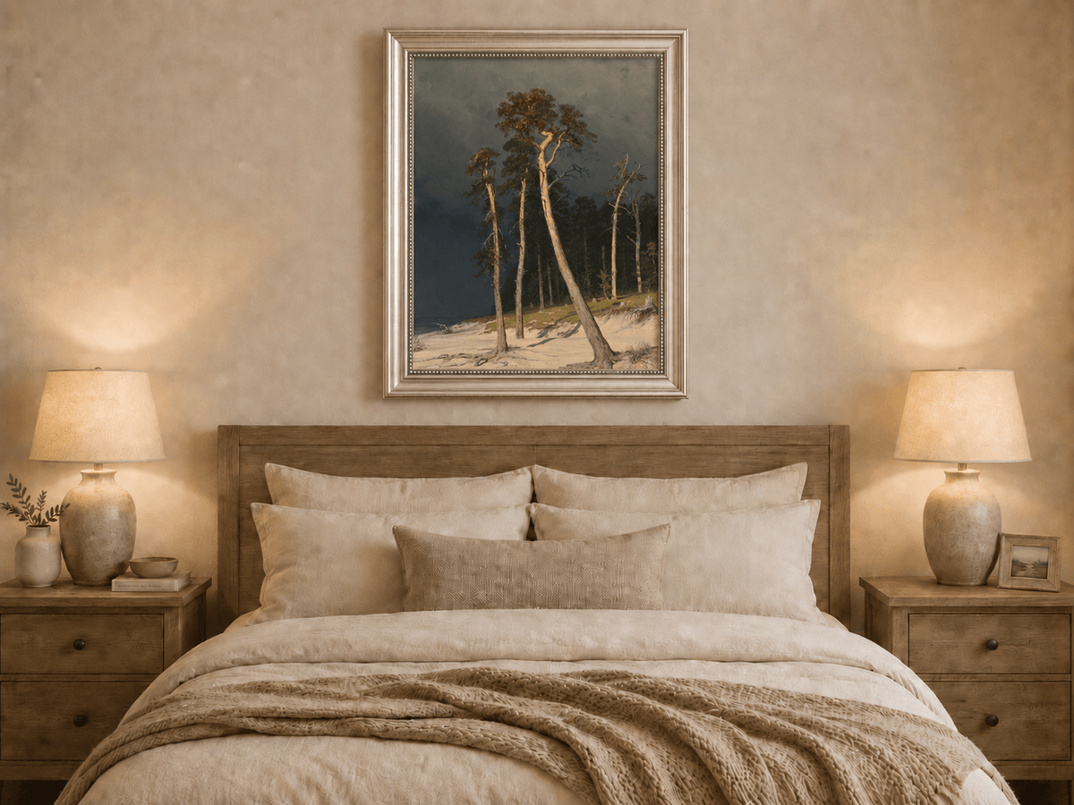 Framed hand-painted coastal forest oil painting with tall pines on a sandy shore displayed above a wooden bed in a neutral bedroom.
