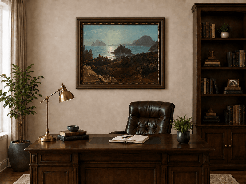 Framed hand-painted coastal oil painting with a rocky shoreline, wildlife and distant sea stacks displayed above a traditional home office desk.