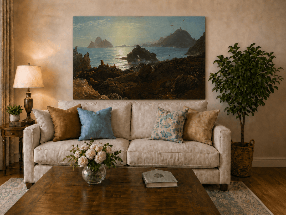 Unframed hand-painted coastal oil painting with a rocky shoreline, wildlife and distant sea stacks displayed above a neutral living room sofa.