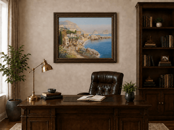 Framed hand-painted coastal village oil painting with blue sea and a rocky shoreline displayed above a traditional home office desk.
