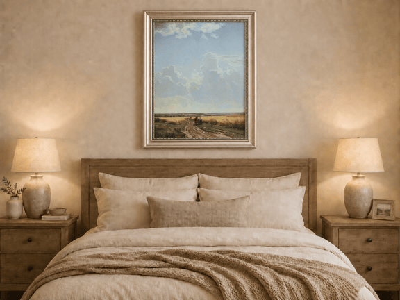 Framed hand-painted countryside oil painting with a road through wheat fields beneath broad clouds displayed above a wooden bed in a neutral bedroom.