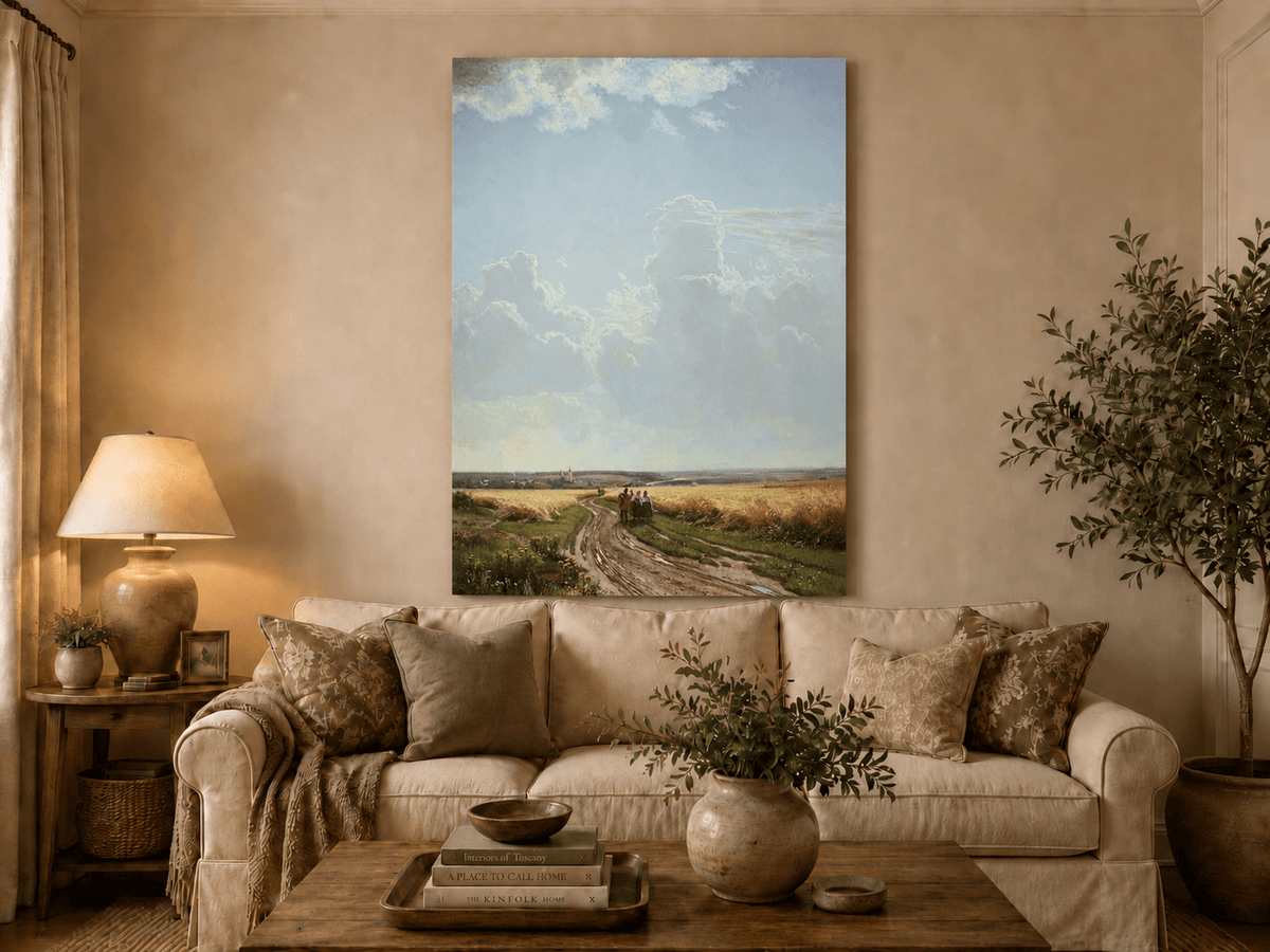 Unframed hand-painted countryside oil painting with a road through wheat fields beneath broad clouds displayed above a neutral living room sofa.