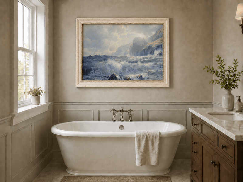 Framed hand-painted seascape oil painting with crashing waves along a rocky coastal shore displayed above a freestanding bathtub.