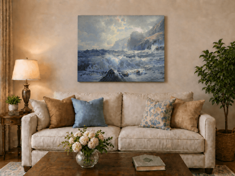Unframed hand-painted seascape oil painting with crashing waves along a rocky coastal shore displayed above a neutral living room sofa.