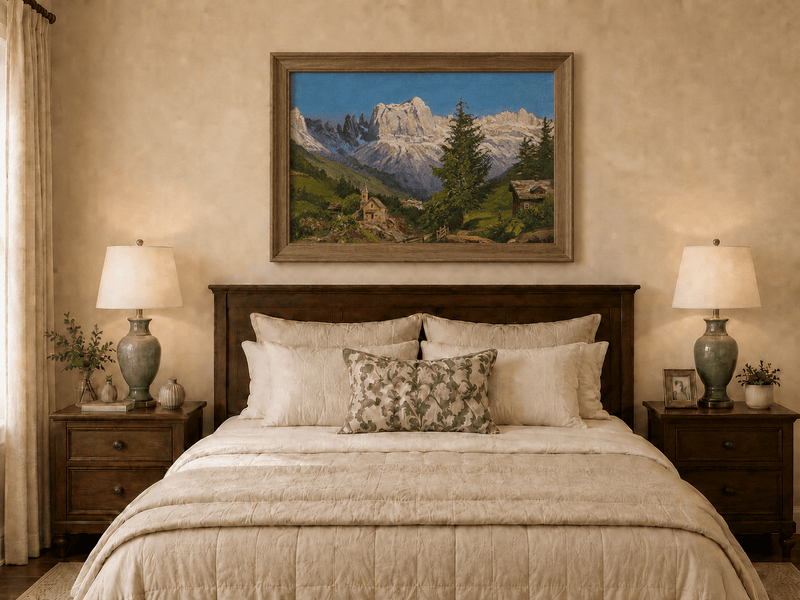 Framed hand-painted Dolomite village oil painting beneath dramatic alpine peaks displayed above a wooden bed in a neutral bedroom.