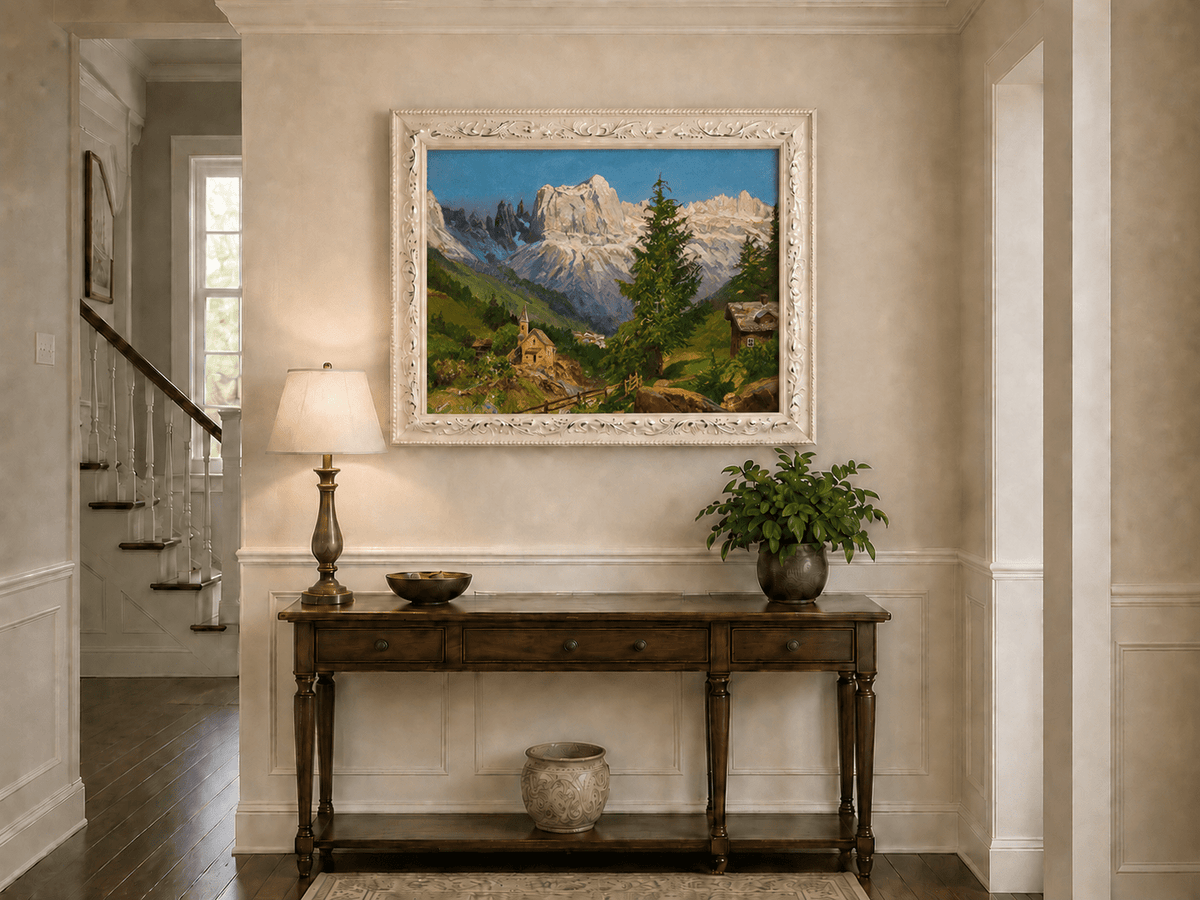 Framed hand-painted Dolomite village oil painting beneath dramatic alpine peaks displayed above an entryway console table.