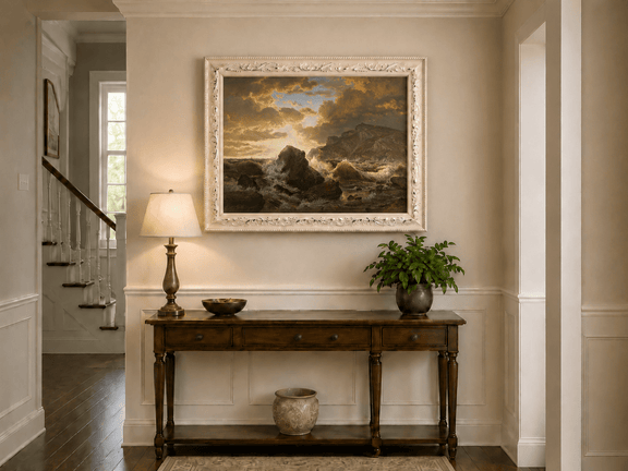 Framed hand-painted dramatic coastal seascape with crashing waves and dark rocks displayed above an entryway console table.