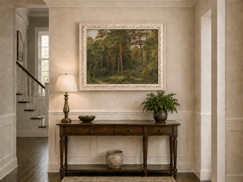 Framed hand-painted woodland oil painting with a secluded cabin among autumn trees displayed above an entryway console table.
