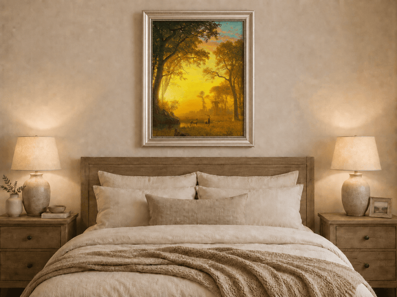 Framed hand-painted forest oil painting with deer by a stream at golden sunset displayed above a wooden bed in a neutral bedroom.
